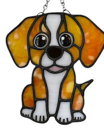 Stained glass sun catcher of a sitting beagle puppy in amber and white glass.